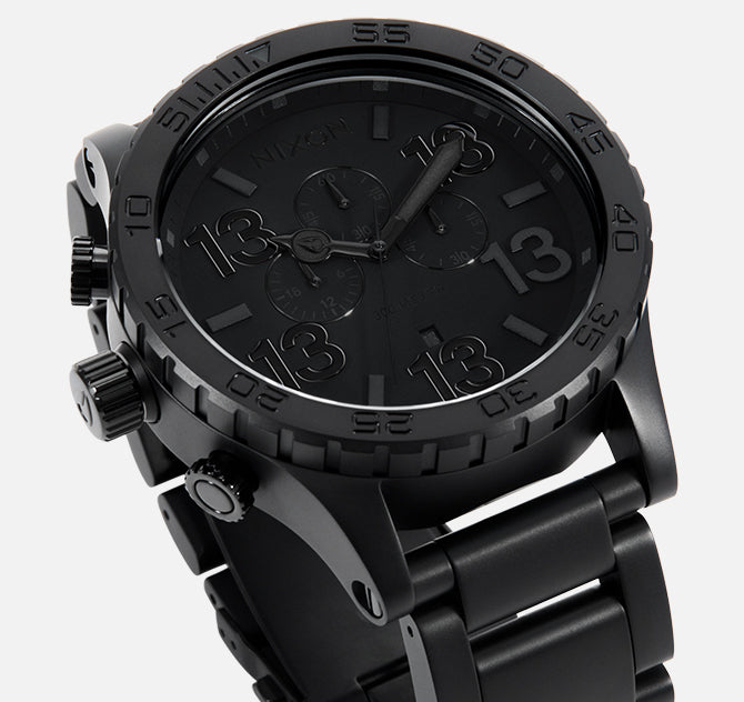 Black Nixon "Friday the 13th" chronograph watch with prominent "13" hour markers.