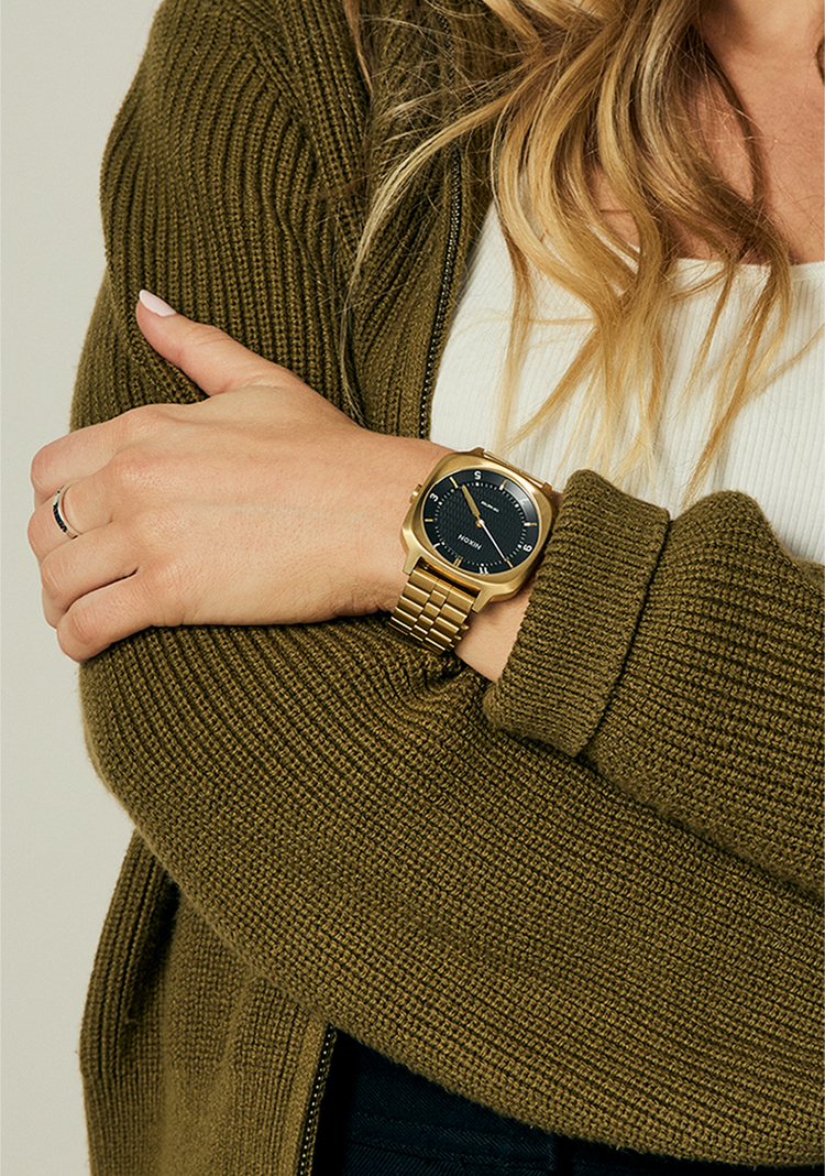 Woman crossing her arms while wearing a Nixon Fremont 40 analog watch in gold